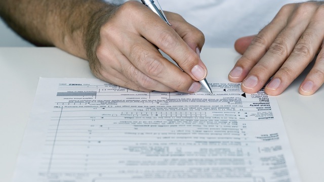 Man Filling out Tax Form
