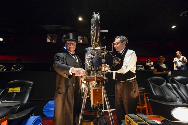 Joe Rinaudo, assisted by Gary Gibson, operating the 1909 hand-cranked Power's Model 6 Cameragraph Motion Picture Machine